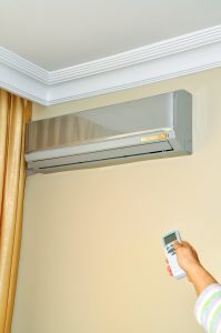 ductless-unit-on-wall-hand-with-remote